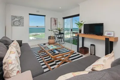 a living room with a couch and a table at 49 Whalerock in Hermanus