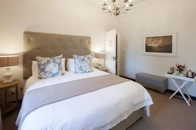 a bedroom with a large white bed with blue pillows at Elgin Vintners Country House in Elgin