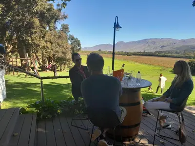 a group of people sitting around a table with a barrel at Elgin Vintners Country House in Elgin