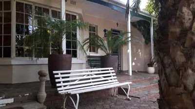 a white bench sitting in front of a house at MAVILLA STELLENBOSCH B&B in Stellenbosch