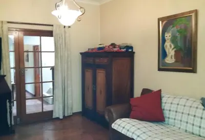 a living room with a couch and a table and a window at MAVILLA STELLENBOSCH B&B in Stellenbosch