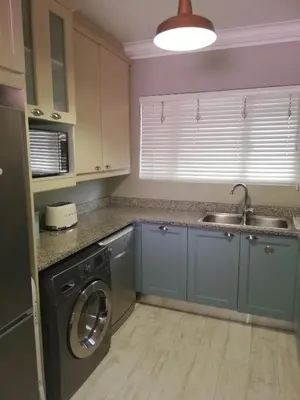 a kitchen with a washing machine and a sink at 504 Witsand in Bloubergstrand
