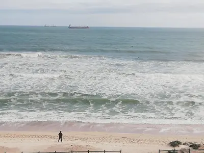 a man standing on the beach looking at the ocean at 504 Witsand in Bloubergstrand