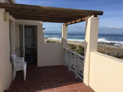 a balcony with a view of the ocean at Huisi by di C in Hermanus