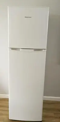 a white refrigerator freezer sitting in a room at Caesar's Self-catering Open Plan Suite in Somerset West