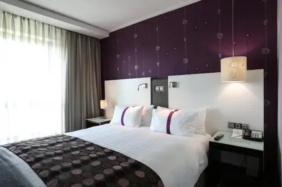 a hotel room with a large bed and a window at Hotel Verde Cape Town Airport in Matroosfontein
