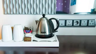 a tea kettle sitting on a counter with cups at Hotel Verde Cape Town Airport in Matroosfontein