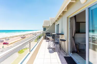 a balcony with a view of the beach at Sea Spray B403 by CTHA in Bloubergstrand