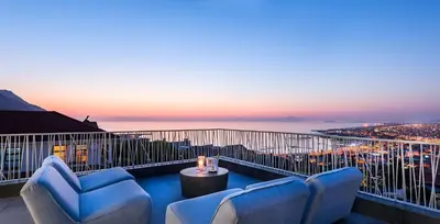a balcony with couches and a view of the city at Kianga in Gordonʼs Bay