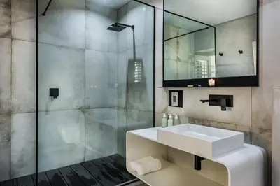 a bathroom with a white sink and a shower at Kianga in Gordonʼs Bay