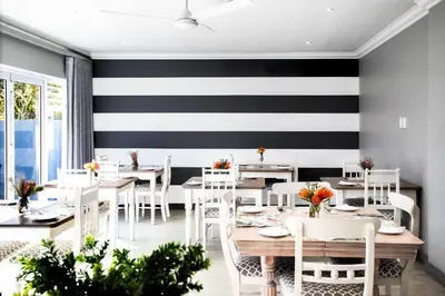 a restaurant with black and white stripes on the wall at Whale Coast Ocean Villa in Hermanus