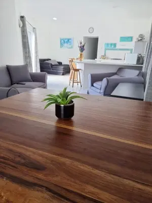 a living room with a wooden table with a plant on it at Pelican Accommodation Ottery in Cape Town