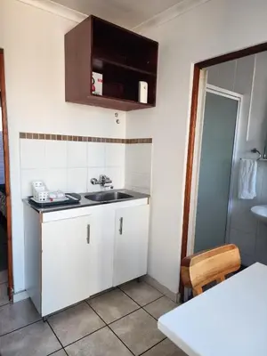 a small kitchen with a sink and a counter at Pelican Accommodation Ottery in Cape Town