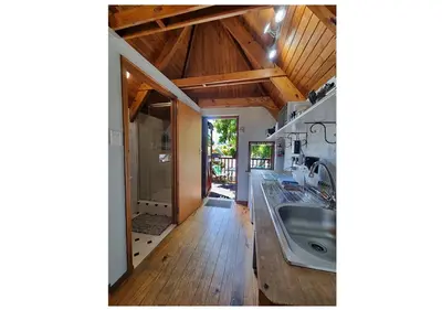 a kitchen with wooden ceilings and a large sink at Studio on McLeod - Private Self-catering Apartment in Somerset West