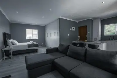 a living room with a couch and a bed at Milo's Sky Grey Guest House - No Load shedding in Cape Town