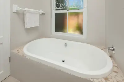 a white sink in a bathroom with a window at Villa Blu Guesthouse in Hermanus