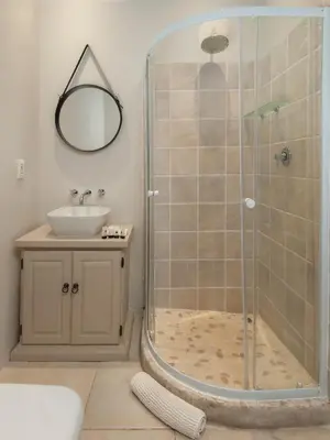 a bathroom with a shower and a sink at Villa Blu Guesthouse in Hermanus