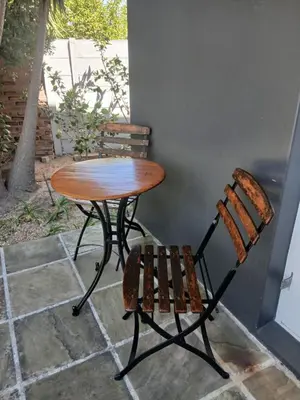 a wooden table and a bench next to a table and chair at Villa Blu Guesthouse in Hermanus
