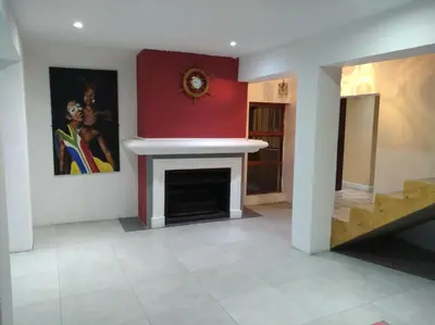 a living room with a fireplace and a red wall at Liziwe's Guest House in Matroosfontein