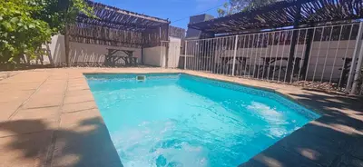 a swimming pool next to a fence at Kelkiewyn Guesthouse Caledon in Caledon