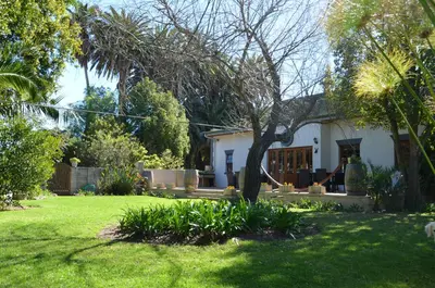 a white house with a yard with a tree at B&B Sauvignon Country Lodge in Wellington