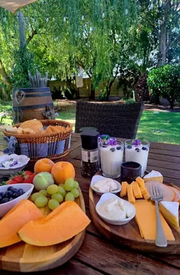 a wooden table topped with lots of different types of food at B&B Sauvignon Country Lodge in Wellington