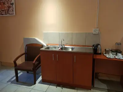 a kitchen with a sink and a chair next to a table at Canterbury Self-catering in Bellville