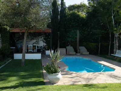 a swimming pool in a yard with a patio at Cummings Guesthouse in Wellington