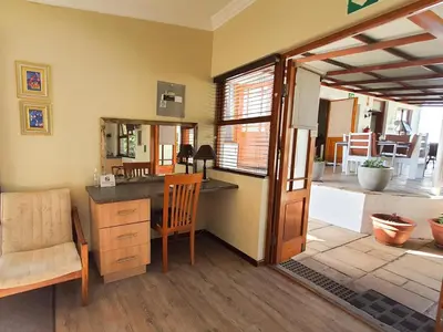 a room with a desk with a chair and a mirror at Cummings Guesthouse in Wellington