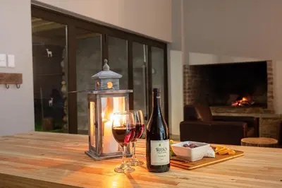 a bottle of wine and a glass on a table at Steenbok Farm Cottages Steenbok cottage in Wolseley