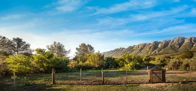 a fence in a field with mountains in the background at Steenbok Farm Cottages Steenbok cottage in Wolseley