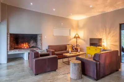 a living room with leather furniture and a fireplace at Steenbok Farm Cottages Steenbok cottage in Wolseley