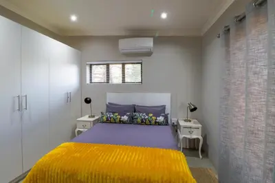 a bedroom with a bed with a yellow blanket at Steenbok Farm Cottages Steenbok cottage in Wolseley