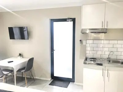 a kitchen with a table and a white table and chairs at Selton Guesthouse in Cape Town