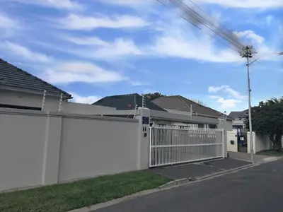 a white fence in front of some houses at Selton Guesthouse in Cape Town