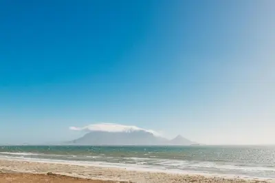a beach with a mountain in the background at Voir la Mer - Blouberg Beach in Bloubergstrand