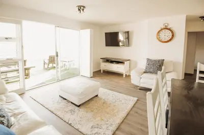 a living room with a couch and a table at Voir la Mer - Blouberg Beach in Bloubergstrand
