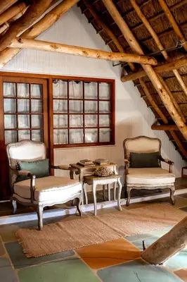 a living room with two chairs and a table at Cape Dutch @ Keerweder in Franschhoek