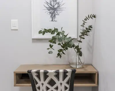 a vase with a plant on a wooden table at Casa Bella Stellenbosch - Jan Cats No 4 in Stellenbosch