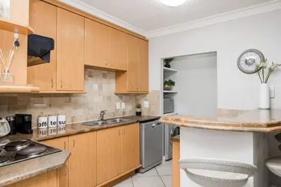 a kitchen with wooden cabinets and stainless steel appliances at Casa Bella Stellenbosch - Jan Cats No 4 in Stellenbosch