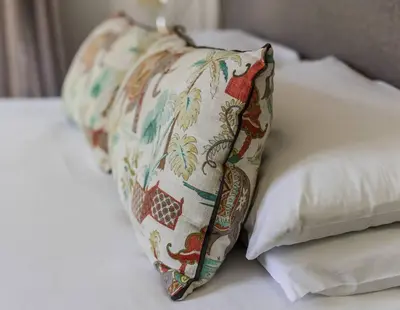 a pillow sitting on a bed next to two pillows at Casa Bella Stellenbosch - Jan Cats No 4 in Stellenbosch