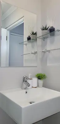 a white bathroom sink with a mirror and plants at Casa Bella Stellenbosch - Jan Cats No 4 in Stellenbosch