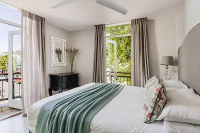 a bedroom with a large bed and a balcony at Casa Bella Stellenbosch - Jan Cats No 4 in Stellenbosch