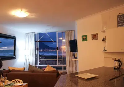 a living room with a couch and a window at Lagoon Beach Neptune Isle Cape Town in Cape Town