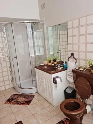a bathroom with a shower and a toilet and a sink at Angel's Corner in Cape Town