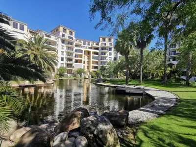 a large apartment building with a pond in front of it at Century City Boutique Apartments in Cape Town