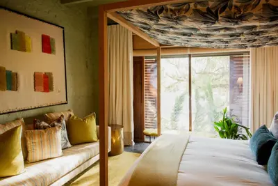 a bedroom with a bed and a couch and a window at Bosjes - Herehuis in Breerivier