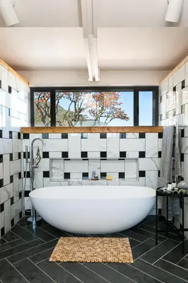 a bathroom with a large white tub and a window at Bosjes - Herehuis in Breerivier