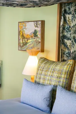 a bedroom with a bed with a lamp and a painting at Bosjes - Herehuis in Breerivier