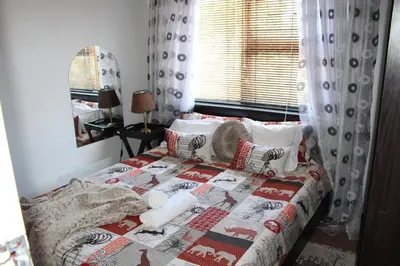 a bedroom with a bed with a quilt on it at Turning Point Bed & Breakfast in Cape Town